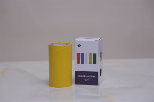 Yellow roll of tape and its packaging box on a light surface with a neutral background